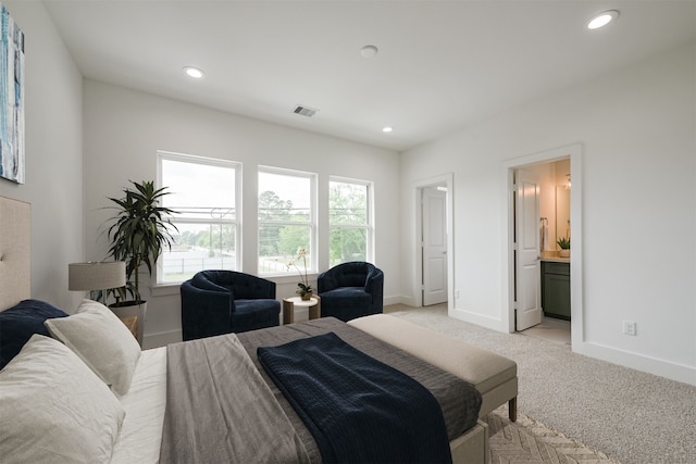 bedroom with light colored carpet and ensuite bath