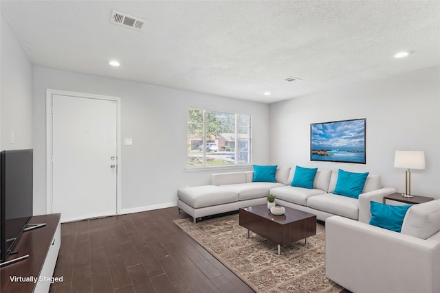 living room featuring dark hardwood / wood-style flooring and a textured ceiling