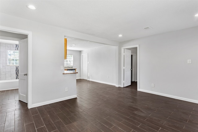 empty room featuring dark wood-type flooring and a textured ceiling