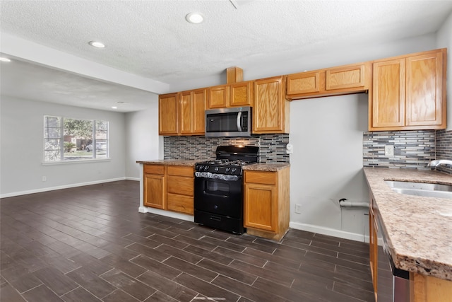 kitchen with backsplash, dark wood-type flooring, sink, a textured ceiling, and stainless steel appliances