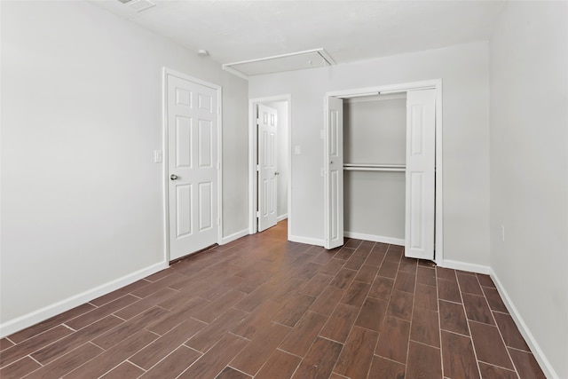 unfurnished bedroom with dark hardwood / wood-style flooring and a closet