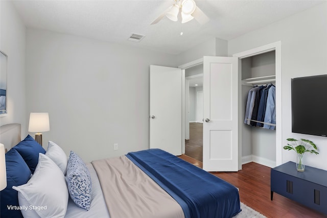 bedroom with a textured ceiling, a closet, ceiling fan, and dark wood-type flooring