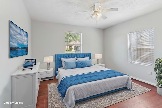 bedroom with a textured ceiling, dark hardwood / wood-style flooring, and ceiling fan