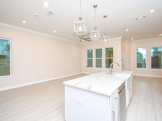 kitchen with light hardwood / wood-style floors, white cabinets, an island with sink, ornamental molding, and decorative light fixtures