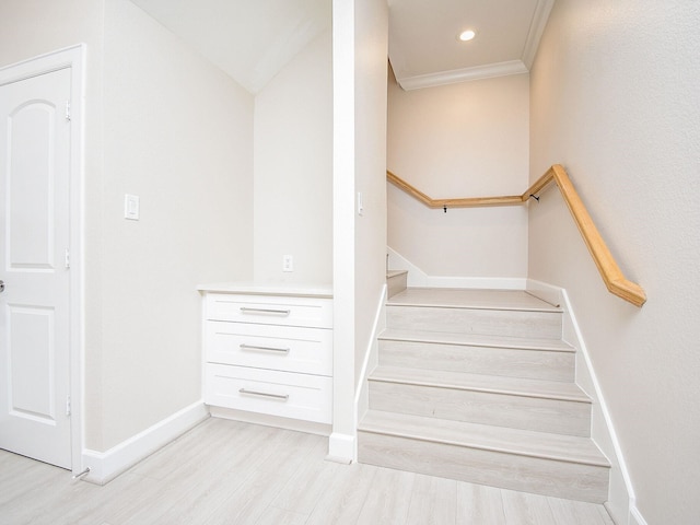 staircase featuring hardwood / wood-style floors and crown molding