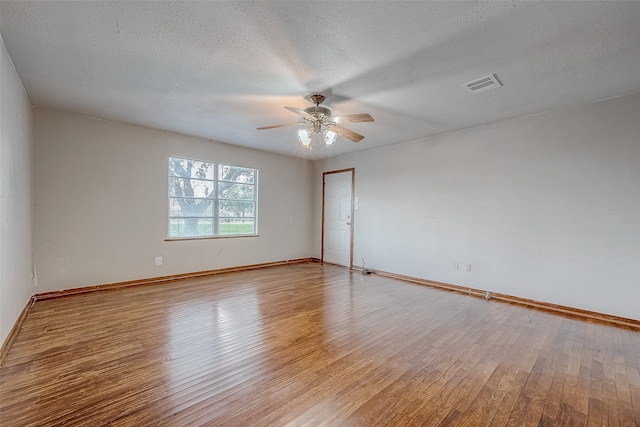 empty room with ceiling fan, a textured ceiling, and light hardwood / wood-style flooring