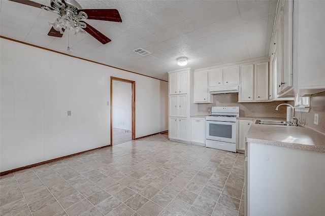 kitchen with white stove, white cabinets, sink, ornamental molding, and ceiling fan