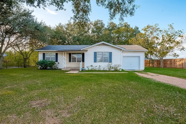 ranch-style house featuring a front yard and a garage