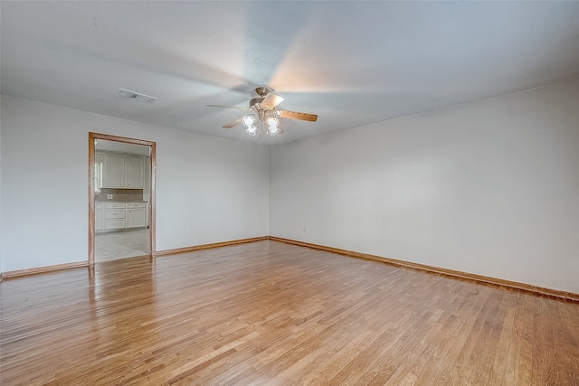 empty room featuring ceiling fan and light hardwood / wood-style flooring