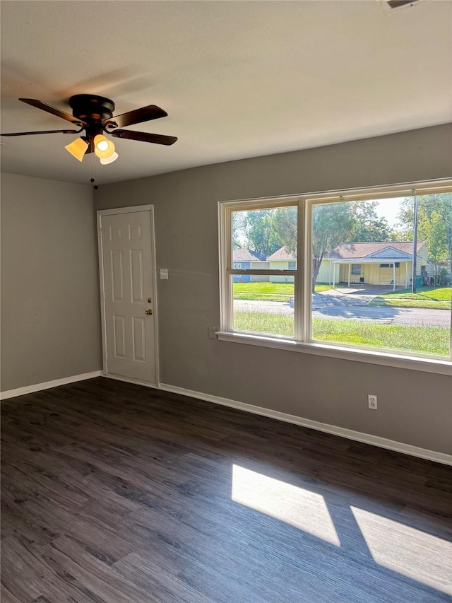 empty room featuring dark hardwood / wood-style flooring and ceiling fan