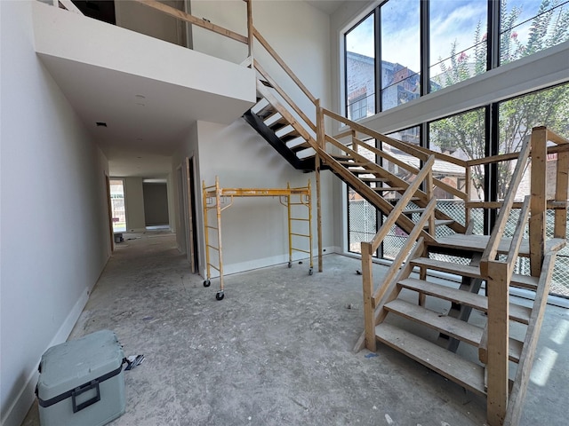 1606 Hazard St, Houston, TX 77019 - staircase with plenty of natural light, a towering ceiling, and baseboards