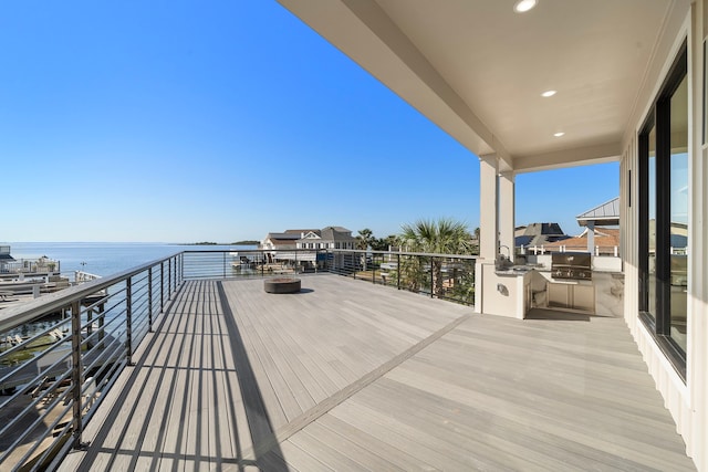 wooden terrace featuring a water view and grilling area