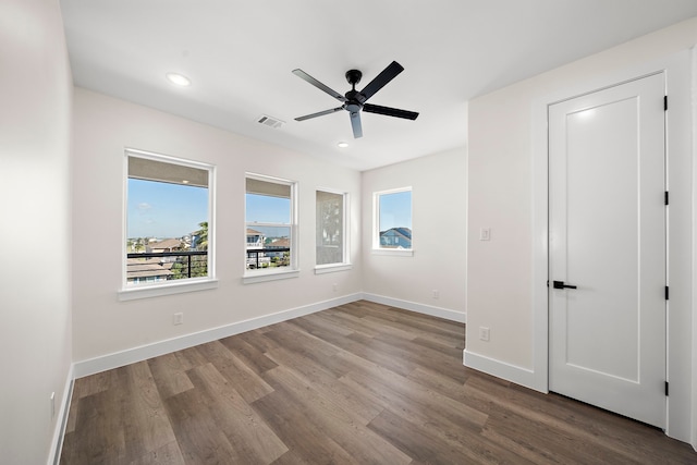 empty room with recessed lighting, visible vents, baseboards, and wood finished floors