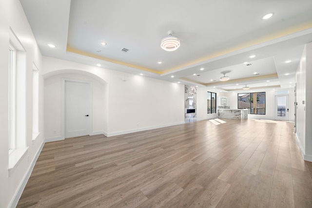 unfurnished living room featuring hardwood / wood-style floors and a raised ceiling