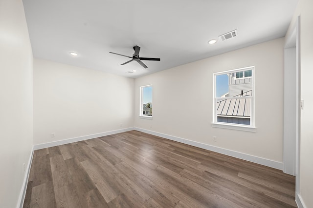 spare room with visible vents, baseboards, and wood finished floors