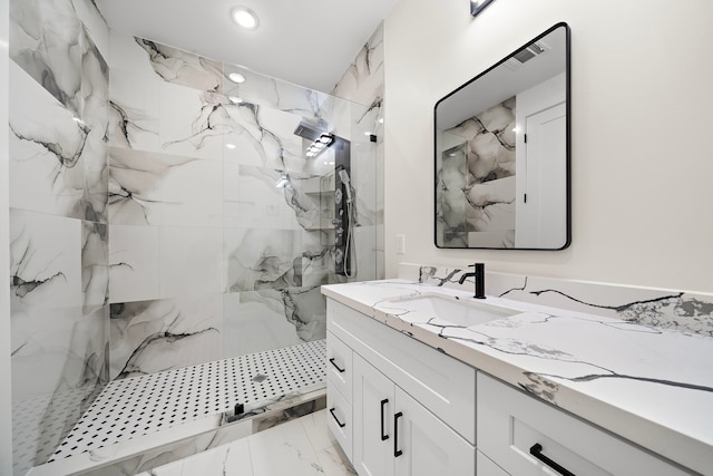 bathroom with marble finish floor, a marble finish shower, recessed lighting, visible vents, and vanity