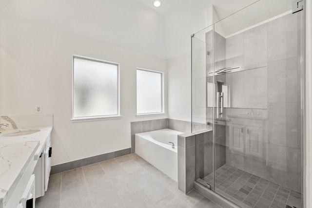 bathroom with plus walk in shower, vanity, and tile patterned floors