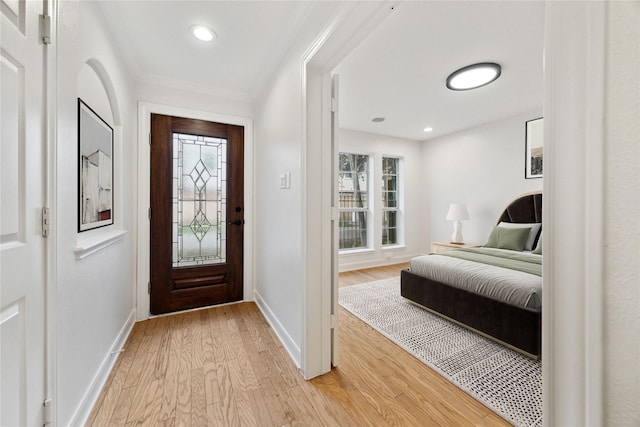 entryway featuring crown molding and light hardwood / wood-style floors