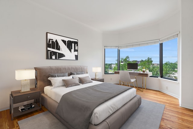 bedroom featuring light hardwood / wood-style floors and crown molding