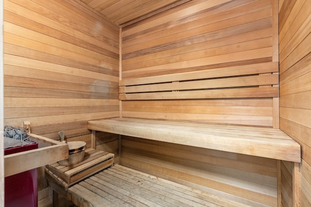 view of sauna / steam room featuring wooden ceiling and wooden walls