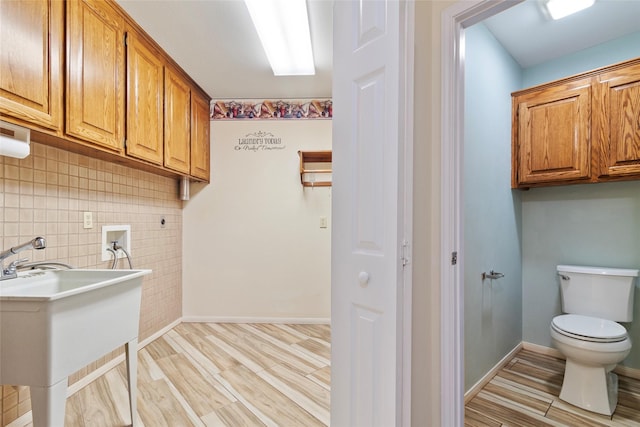 washroom featuring sink, washer hookup, and light wood-type flooring