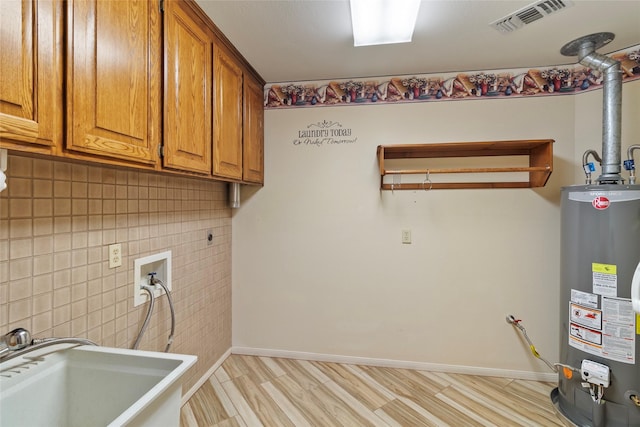 laundry room with light hardwood / wood-style flooring, cabinets, gas water heater, and sink