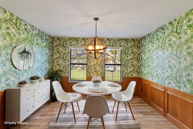 dining space with an inviting chandelier and light hardwood / wood-style flooring