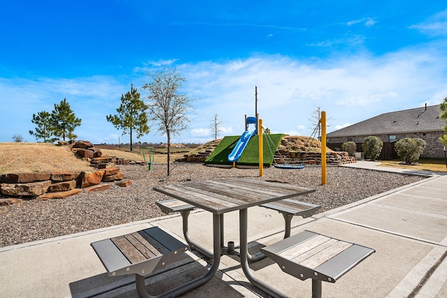 view of playground with a patio area