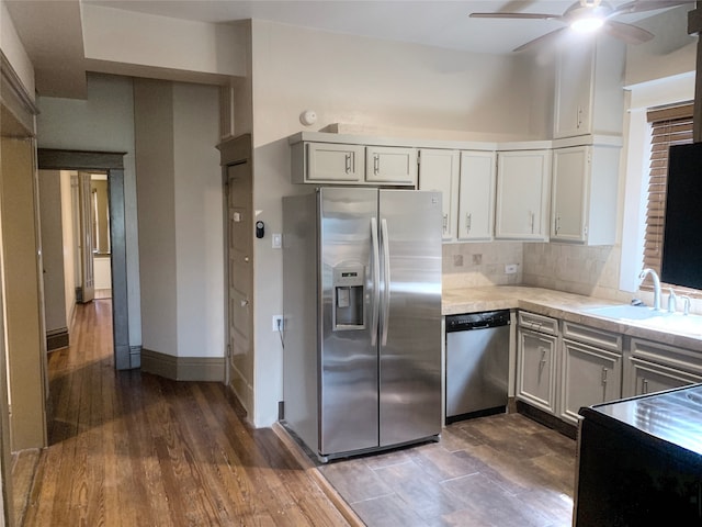 kitchen featuring tasteful backsplash, stainless steel appliances, sink, dark wood-type flooring, and ceiling fan