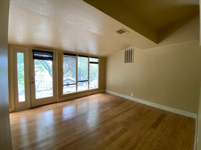 spare room with hardwood / wood-style flooring and a textured ceiling