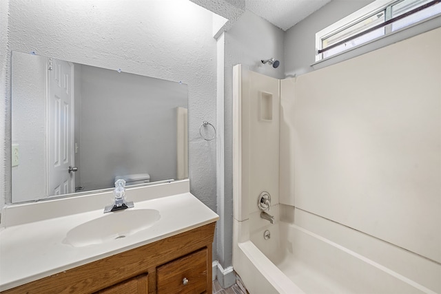 full bathroom featuring toilet, vanity, shower / bathtub combination, and a textured ceiling