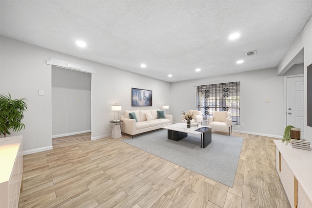 living room featuring light hardwood / wood-style floors and a textured ceiling