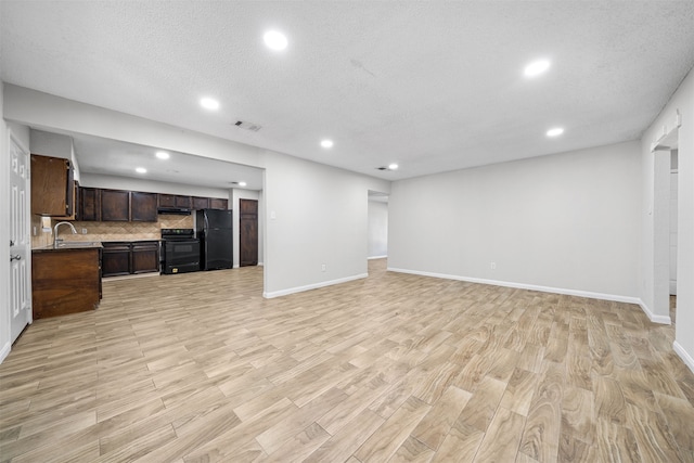 living room featuring light hardwood / wood-style floors, a textured ceiling, and sink