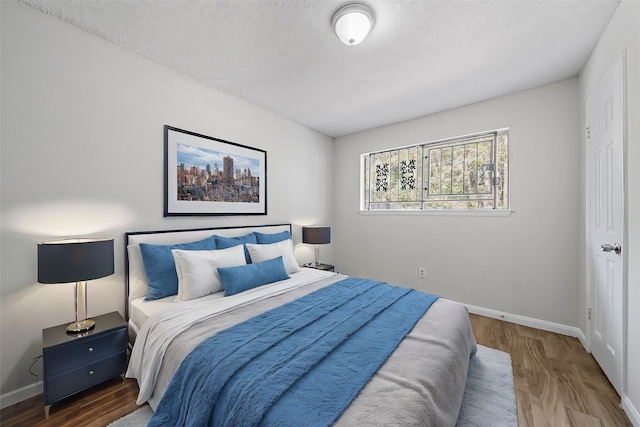 bedroom with dark wood-type flooring and a textured ceiling