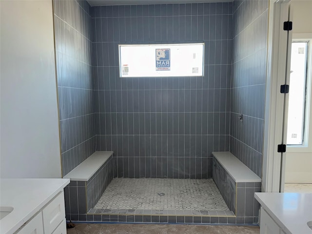 bathroom featuring a tile shower and vanity