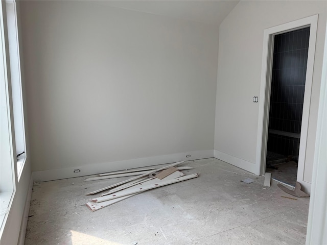 unfurnished room with baseboards