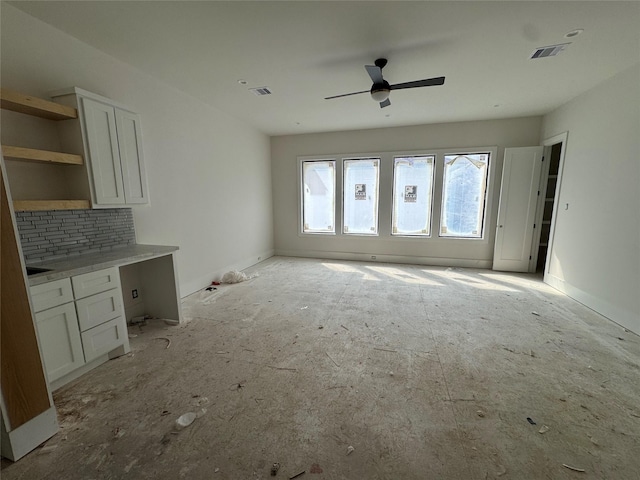 unfurnished living room featuring visible vents and ceiling fan