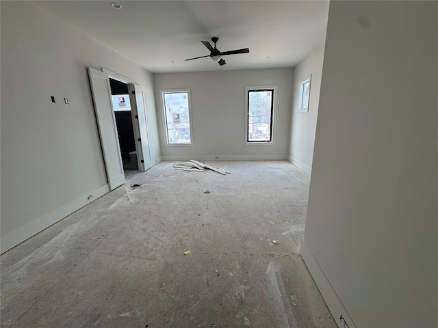 interior space with ceiling fan and baseboards