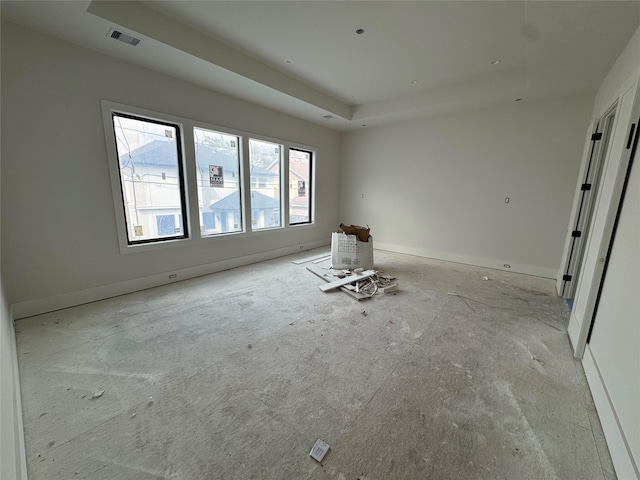 empty room featuring visible vents and a tray ceiling