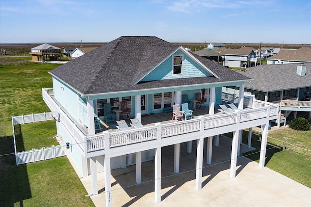 rear view of property featuring a deck, a patio, and a yard