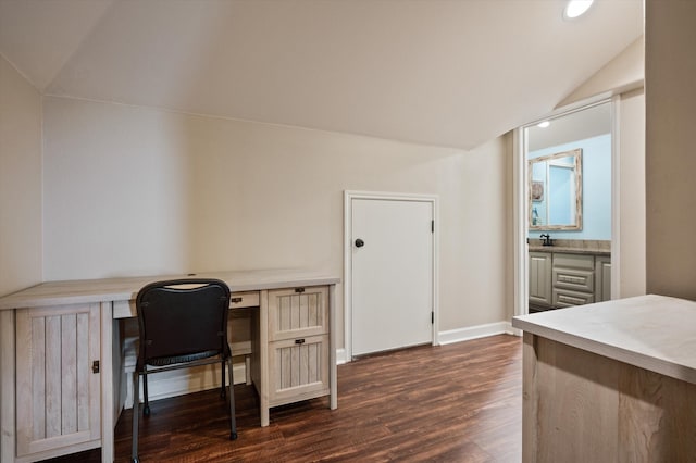 office space with dark wood-type flooring, built in desk, sink, and lofted ceiling