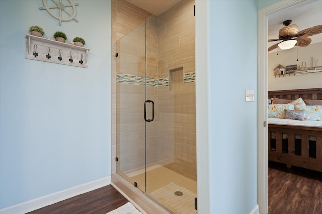 bathroom featuring hardwood / wood-style floors, an enclosed shower, and ceiling fan