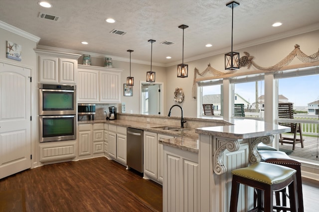 kitchen featuring sink, a breakfast bar area, dark hardwood / wood-style floors, light stone countertops, and appliances with stainless steel finishes