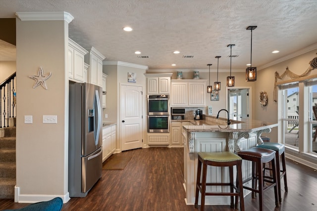 kitchen with stainless steel appliances, pendant lighting, dark wood-type flooring, and light stone counters