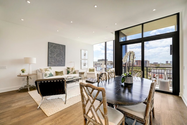 dining space with light wood-type flooring and a wall of windows