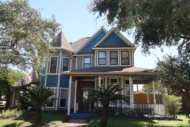 victorian home with a front yard and a porch