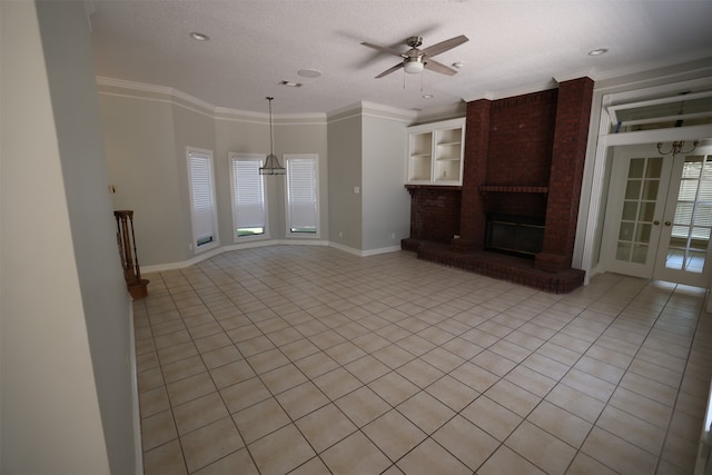 unfurnished living room with crown molding, a textured ceiling, light tile patterned floors, a brick fireplace, and ceiling fan with notable chandelier