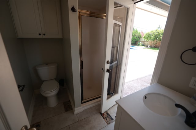 bathroom featuring vanity, a shower with shower door, tile patterned floors, and toilet