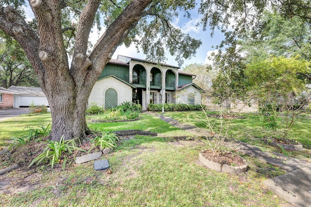 view of front facade featuring a front lawn, a garage, and a balcony