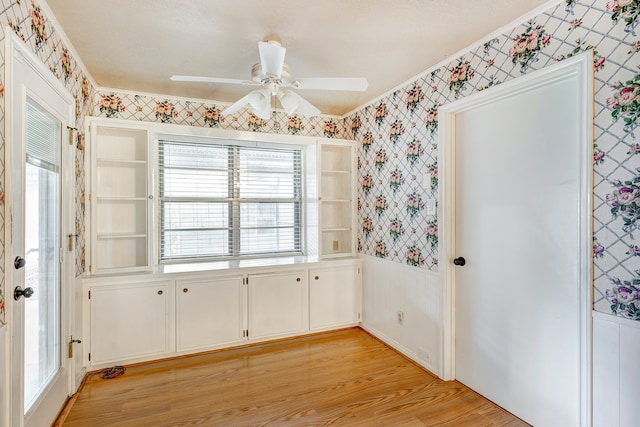 unfurnished dining area with ceiling fan, light hardwood / wood-style floors, and crown molding